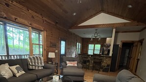 A cozy log cabin interior with a living room featuring two sofas, a coffee table, and a fireplace. - "Deacon Escape", incredible and quiet getaway. (Newland)