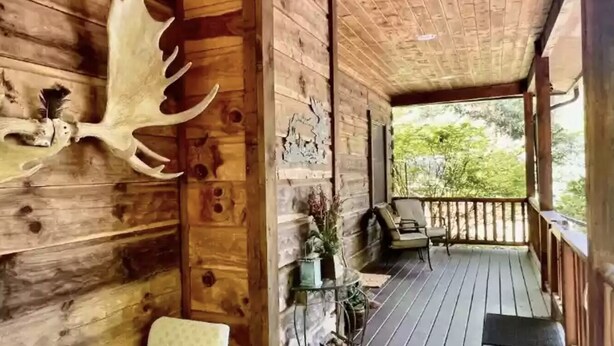 A wooden cabin with a porch, a mounted deer head, and a view of greenery. - "Deacon Escape", incredible and quiet getaway. (Newland)