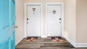 A hallway with two white doors labeled A and B, each with a 'Welcome' sign and a butterfly decoration.