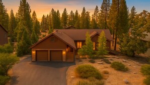 A two-story wooden cabin with a garage, surrounded by a forested landscape. - The Restful Rose ~ Fireside Vibes + AC Comfort (Shaver Lake)