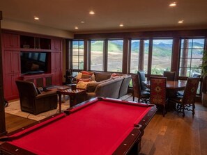 A pool table in a room with a large window, a sofa, and a television. - INCREDIBLE views 1 block to ski area, free bus to town, hot tub, (Crested Butte)