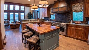 Una cocina amplia con una isla grande, armarios de madera y vistas al exterior.