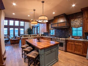 A spacious kitchen with a large island, wooden cabinets, and a view to the outside. - INCREDIBLE views 1 block to ski area, free bus to town, hot tub, (Crested Butte)