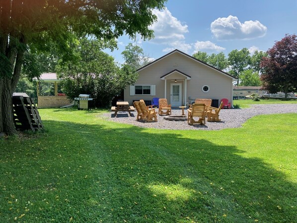 A house with a patio area featuring outdoor furniture and a grill. - Hot Tub, Lake View Cottage, Dog Friendly, Lake Access (Dundee)