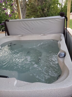 A hot tub with a stone exterior and a cushioned seat. - Hot Tub, Lake View Cottage, Dog Friendly, Lake Access (Dundee)