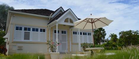 A two-story house with a covered porch and a large umbrella.