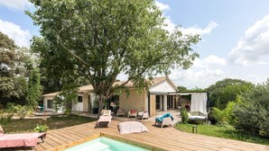 A wooden deck with a swimming pool, lounge chairs, and a covered seating area with cushions. - La Coursive: beautiful luxury home with swimming pool (Montpellier)