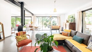 A spacious living room with a sofa, armchair, and a dining area with a table and chairs. - La Coursive: beautiful luxury home with swimming pool (Montpellier)