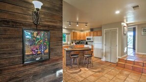 A kitchen with wooden walls, a tiled floor, and a bar area with stools.