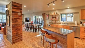 A modern kitchen with a central island, wooden accents, and ample natural light.