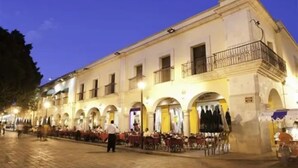 A historic building with multiple arches and balconies, featuring outdoor seating areas and a paved courtyard. - Spacious Condo With King Size Bed And Skyline Views Of Oaxaca! (Oaxaca de Juárez)