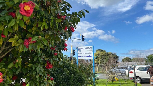 Naamplaatje voor Airport Westney Lodge Budget Accommodatie met een pijl die de ingang aanwijst.