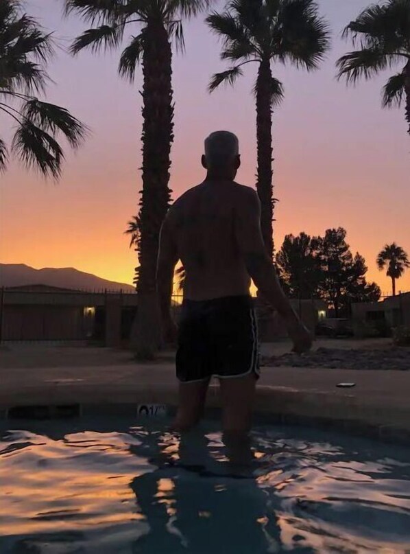 Guests can enjoy a refreshing swim in the pool surrounded by lush palm trees and breathtaking mountain views.