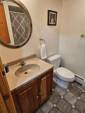 Une salle de bain avec un lavabo, des toilettes et un miroir.