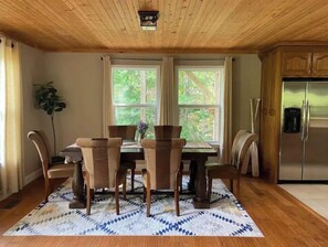 Enjoy meals in this dining area with a table for six, surrounded by large windows offering a view of the outdoors.