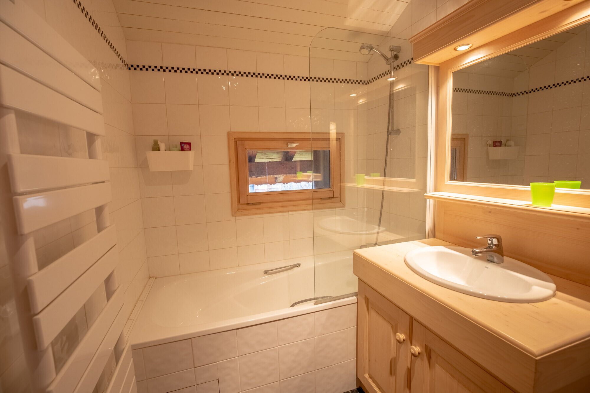 A bathroom with a bathtub, a sink, and a window.