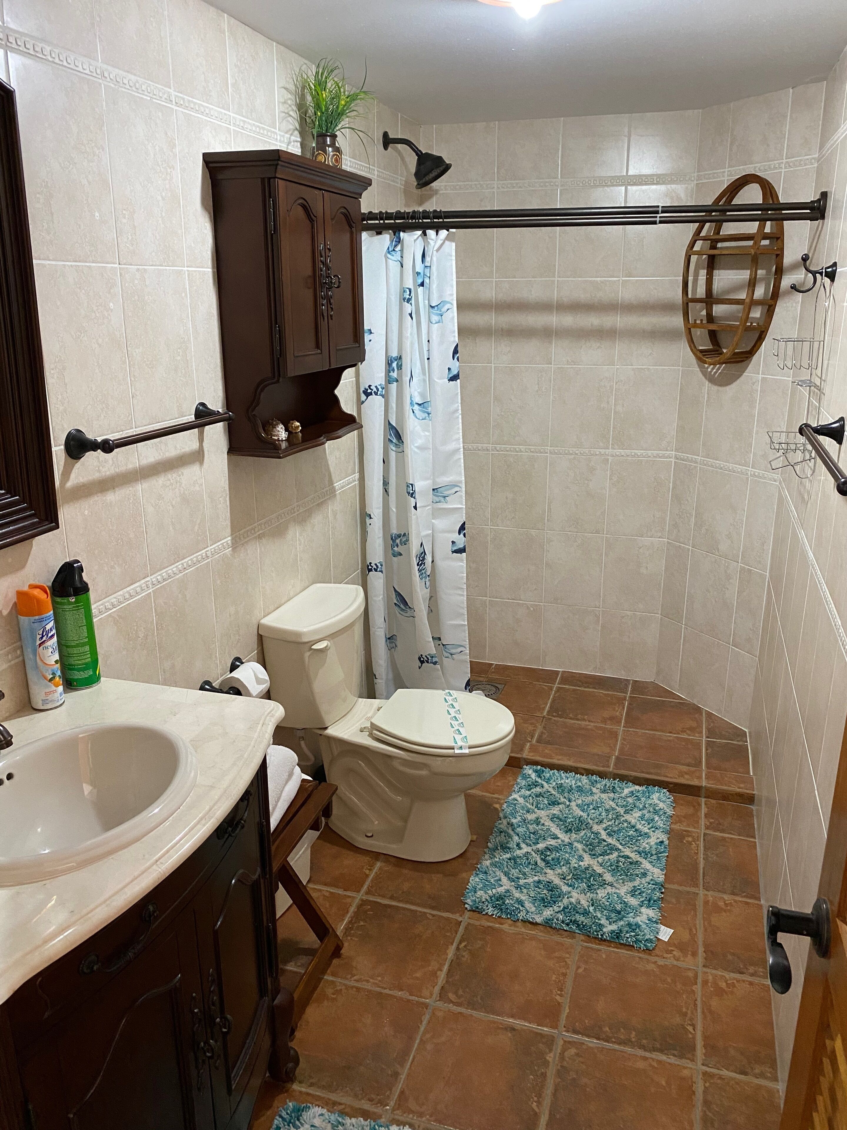 A bathroom with a toilet, sink, and shower area.