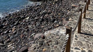 A rocky beach with a clear blue sky and calm sea.