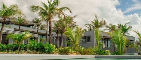 Una piscina con agua cristalina, rodeada de palmeras y edificios modernos.