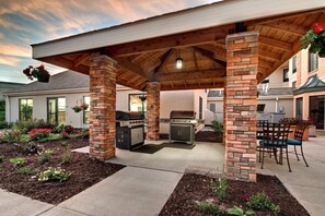 An outdoor patio with a brick grill and seating area. - King Suite | Free Breakfast. Pool and Hot Tub (Middleton)