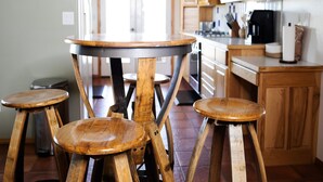 Eine Küche mit Holzhockern, einem runden Tisch und Holzschränken.