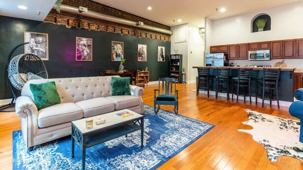 A modern living room with a sofa, coffee table, and a dining area with chairs. - Jump right into the heart of Downtown Knoxville (Knoxville)