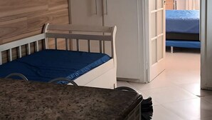 A bedroom with a bed, a wardrobe, and a ceiling fan. - Apto Copacabana - Aluguel Economico (Rio de Janeiro)