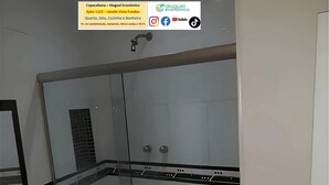 A modern bathroom with a glass shower enclosure, a sink with a mirror, and a black and white checkered floor. - Apto Copacabana - Aluguel Economico (Rio de Janeiro)