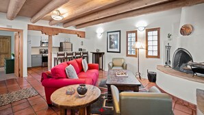 A spacious living area with a red sofa, wooden coffee table, and a fireplace. - Zona Rosa 75, San Antonio (Santa Fe)