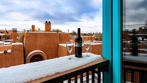 A balcony with a snow-covered table, a bottle of wine, and two glasses. - Zona Rosa 76, Santa Rita (Santa Fe)