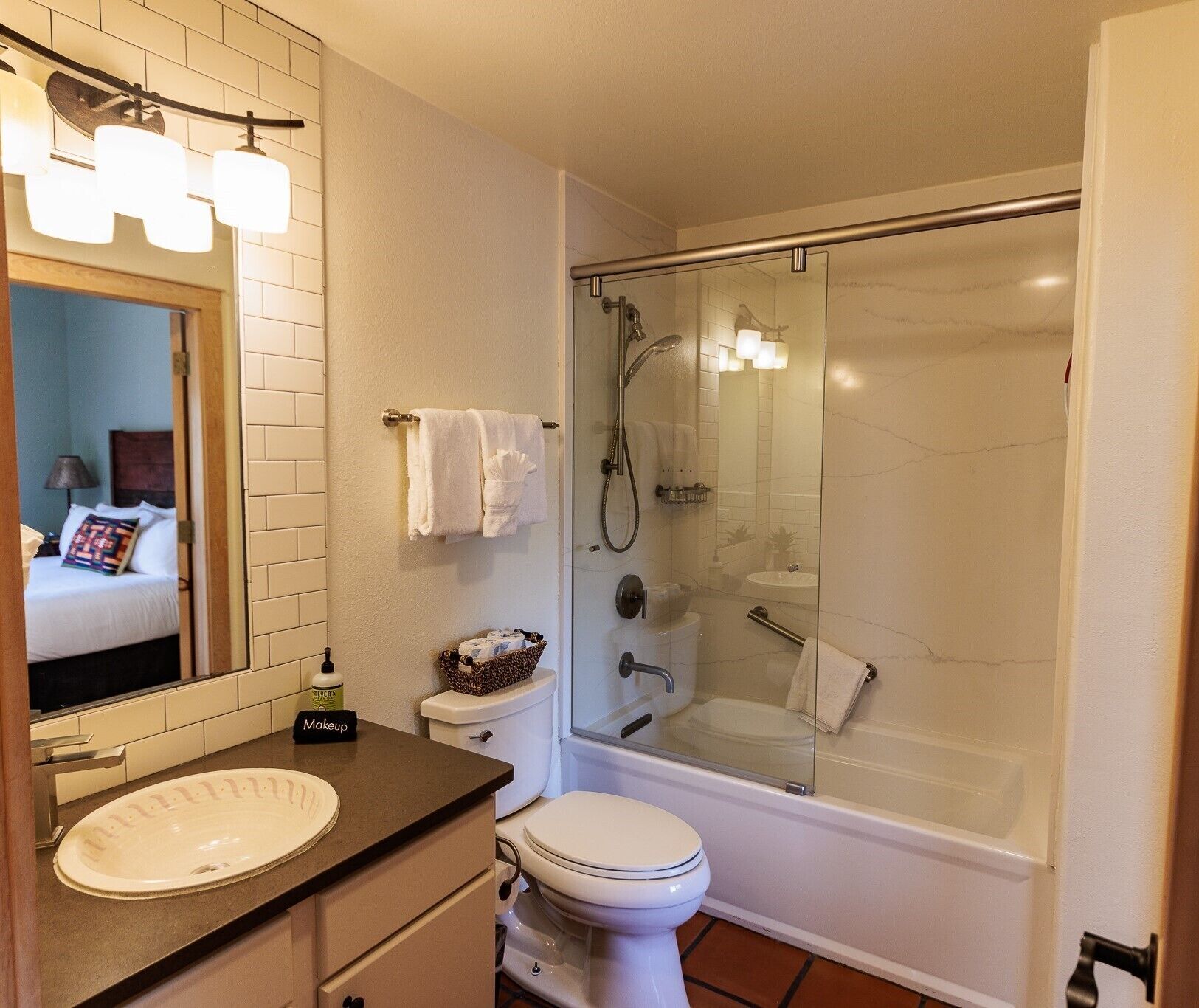 A bathroom with a sink, toilet, and glass-enclosed shower.