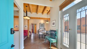 Un couloir avec un plafond en bois, un coin repas avec une table et des chaises, et un banc.