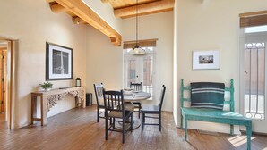 Un coin repas avec une table et des chaises en bois, un banc et un tableau accroché au mur.