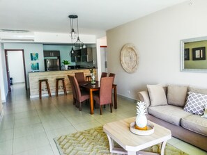 Relax in this stylish living space with a dining area, sofa, and kitchen.