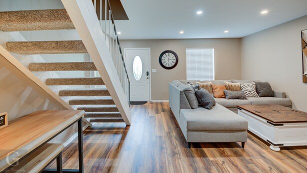 A modern living room with a staircase, a sofa set, and a coffee table. - Quiet, Cozy Townhouse w/ all new appliances and furniture. (Shreveport)