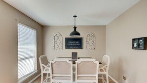 A dining area with a table and chairs, a ceiling light, and wall art. - Quiet, Cozy Townhouse w/ all new appliances and furniture. (Shreveport)