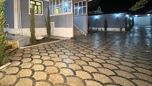 Un edificio con entrada de baldosas y un pequeño porche cubierto con ventanas.