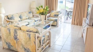 Un salon comprenant un canapé, une table basse et un meuble pour la télévision.
