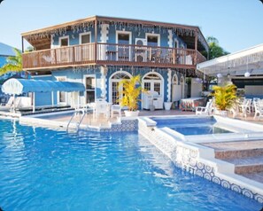 A pool area with a two-story building, outdoor seating, and a clear blue sky. - Ocean Reef Yacht Club & Resort! Unit Sleeps 4 total with Full kitchen! (Freeport)