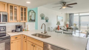 A kitchen with a stainless steel sink, wooden cabinets, a coffee maker, and a dishwasher. - Updated North Myrtle Beach Condo w/ Lazy River! (North Myrtle Beach)