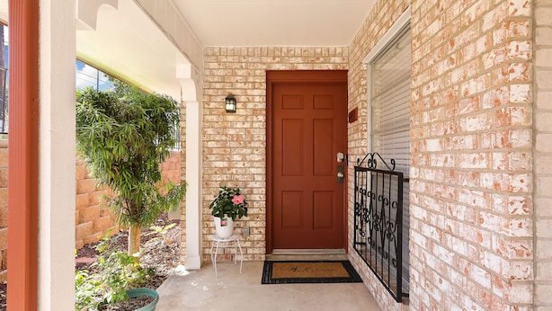 A brick exterior with a brown door, a potted plant, and a doormat. - Enjoy a Peaceful Get-Away - Self check -in (San Antonio)