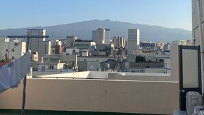 Una azotea con vistas despejadas a un paisaje urbano y montañas a lo lejos.