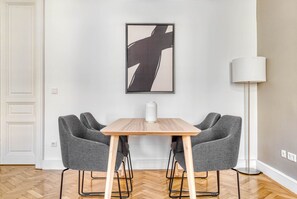 Un coin repas avec une table en bois et deux chaises grises à revêtement rembourré.