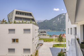Un bâtiment moderne doté d’un toit plat et de grandes fenêtres, offrant une vue sur un lac et des montagnes.