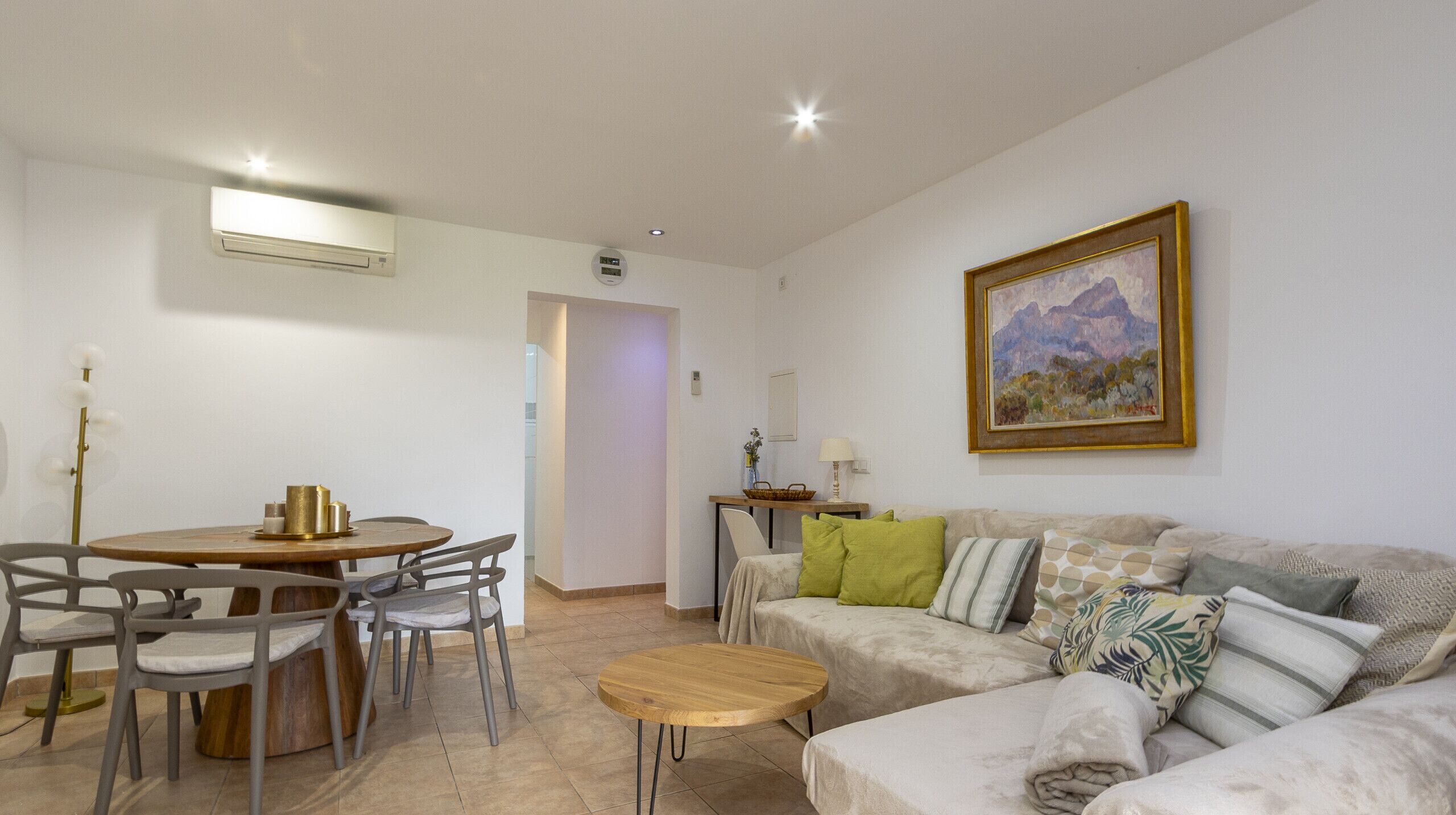 Großzügiges Wohn-Esszimmer mit Sofa in neutralen Tönen, Holztisch und moderner Dekoration.