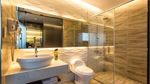 A modern bathroom with a marble sink, a toilet, and a glass-enclosed shower. - Royal Fine Hotel (Kaohsiung)