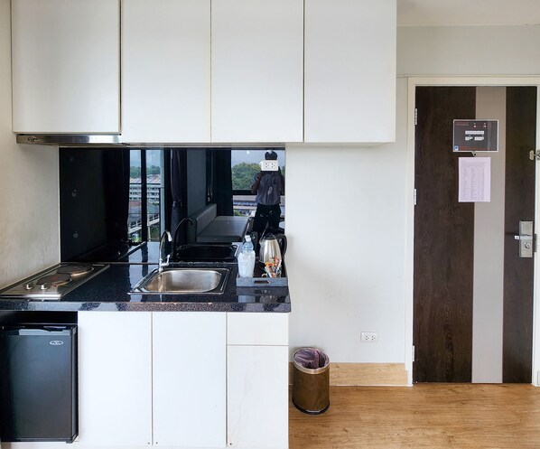 A compact kitchen with a built-in dishwasher, a sink, and a stove.
