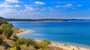 Un paysage côtier avec un ciel dégagé, une plage de sable et une mer calme.