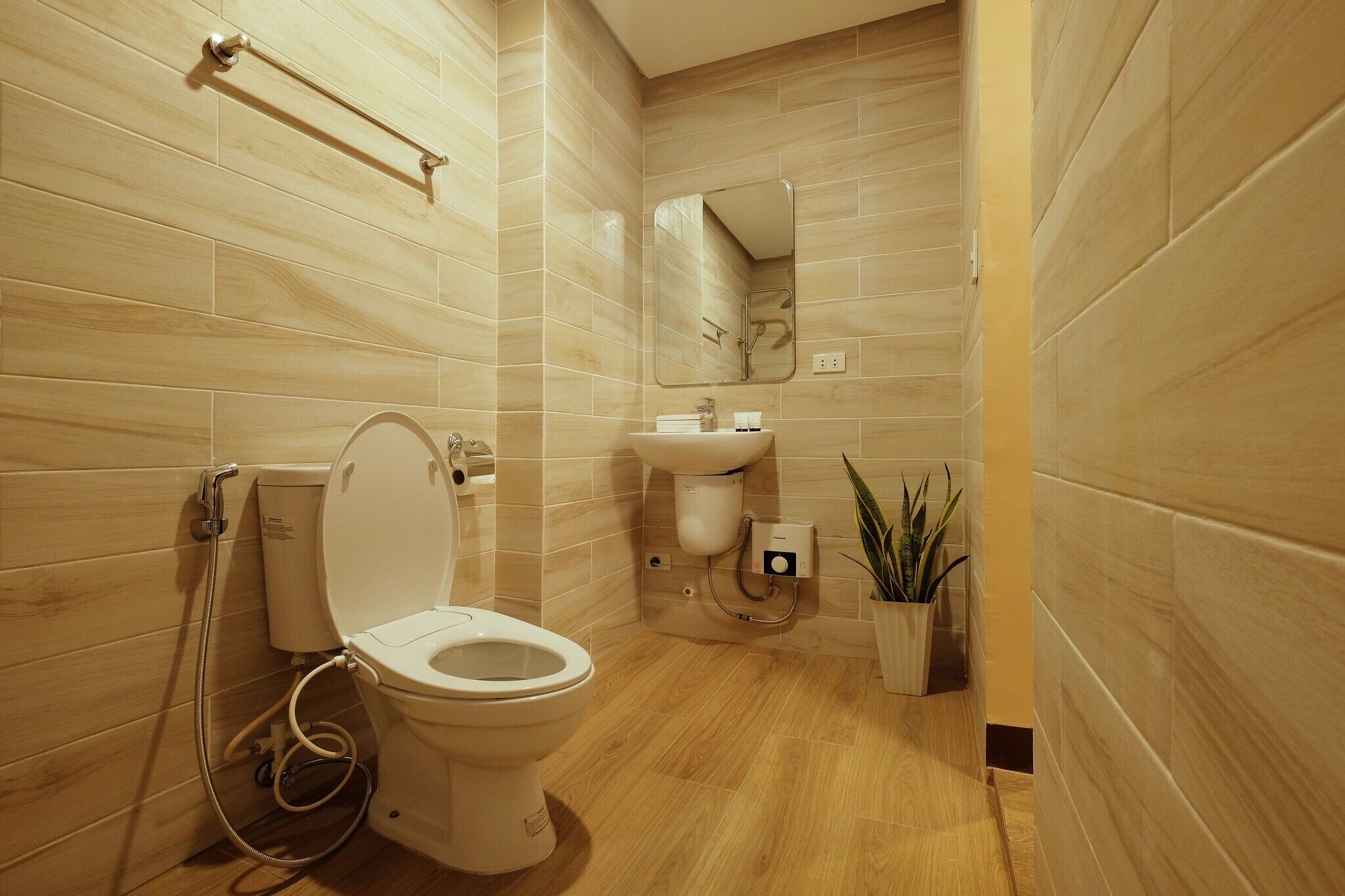 Un baño moderno con inodoro, lavabo y espejo.