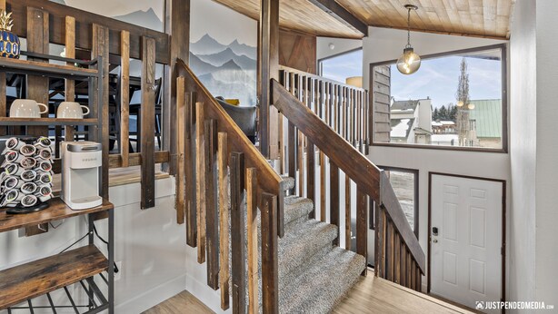 A staircase with wooden railings and a view of mountains through a window. - 🏔Family Friendly - Near Airport & Lake w/ Mountain Views - No Chores (Anchorage)